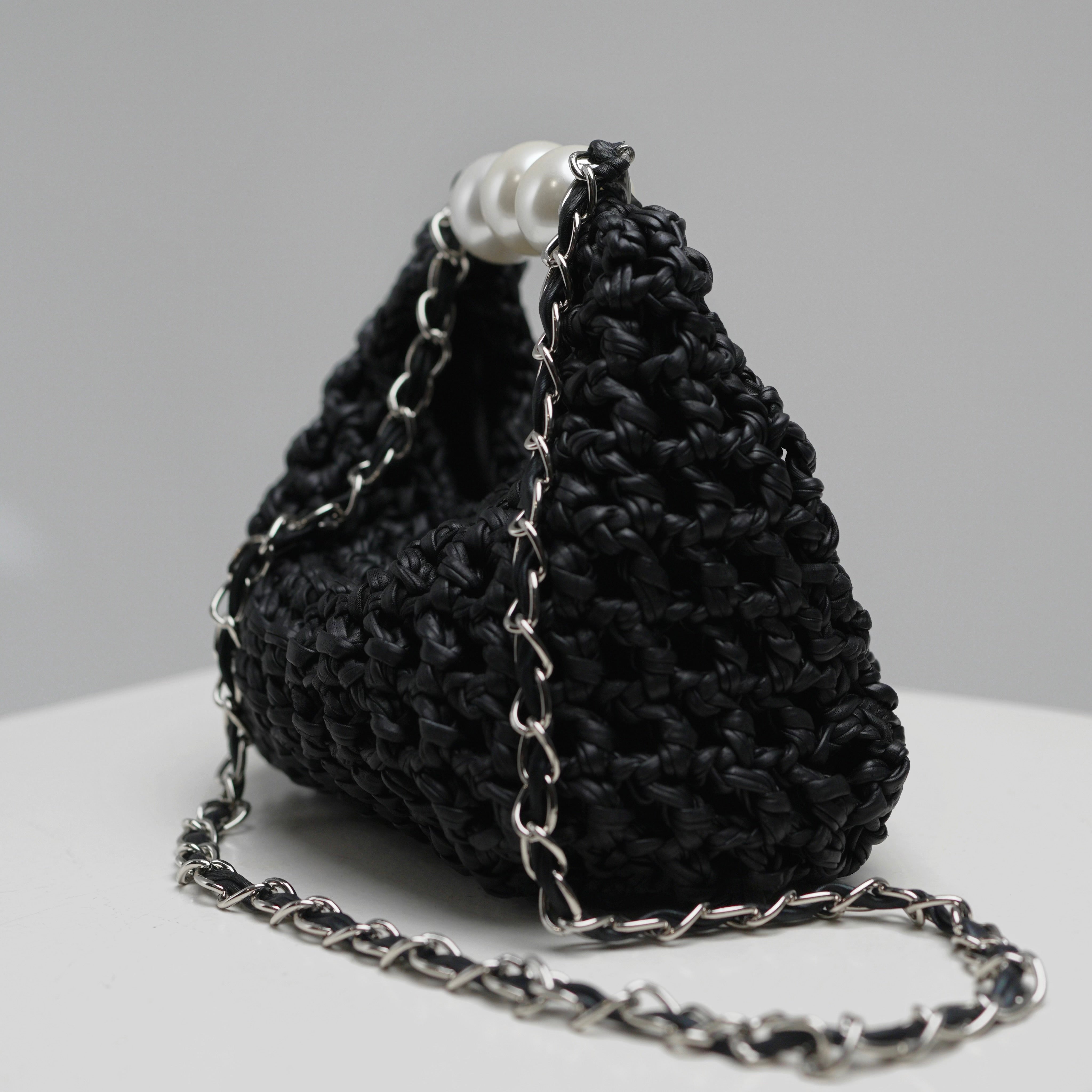 Close-up of Luna bag by ZOEL, black leather texture, pearl handle, silver crossbody chain